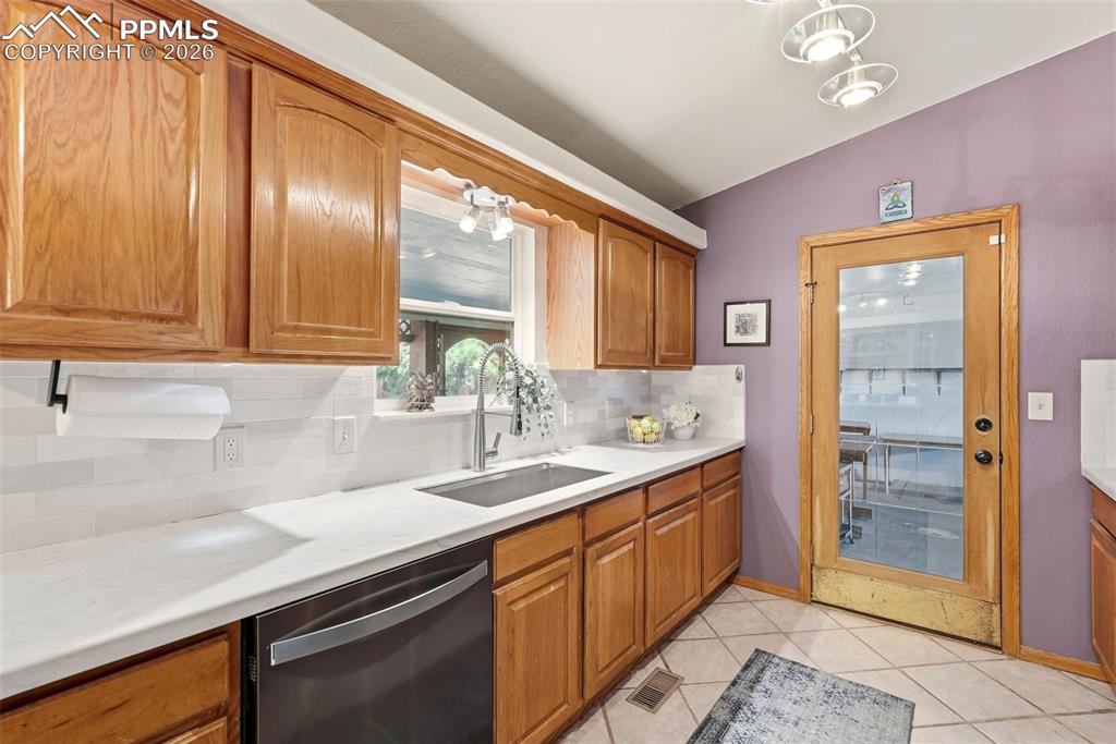 Image 13 of 50: Subway Tile, Tile Floors, Stone Counter Tops, Garage Access, Black Stainles