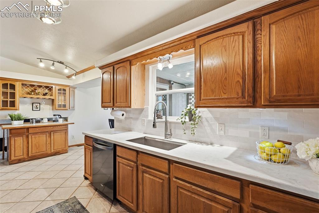 Image 15 of 50: Subway Tile, Tile Floors, Stone Counter Tops, Garage Access, Black Stainles