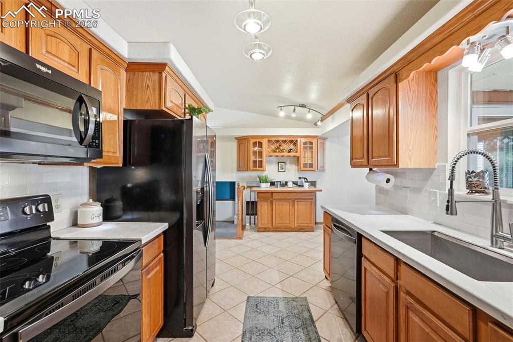 Image 16 of 50: Subway Tile, Tile Floors, Stone Counter Tops, Garage Access, Black Stainles