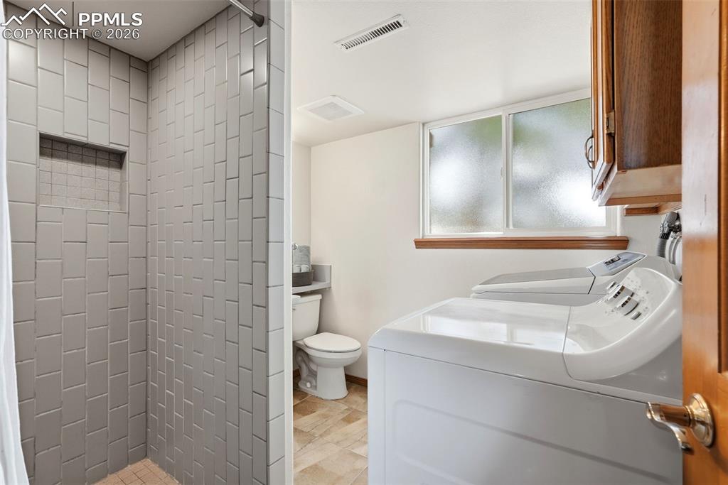 Image 39 of 50: Lower Level, Bathroom, Shower, Laundry, Tile, Window