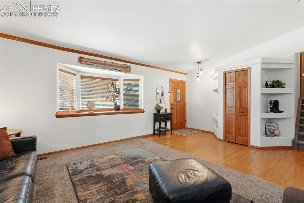 Image 9 of 50: Wood Floors, Vaulted Ceiling, Bay Window, Carpet, Built-Ins, Coat Closet