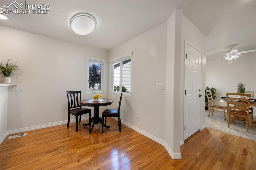 Image 15 of 38: Dining area with light wood finished floors and a ceiling fan