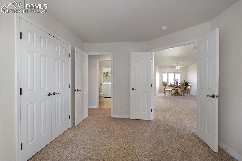 Image 16 of 38: Hall with light colored carpet and washer / clothes dryer