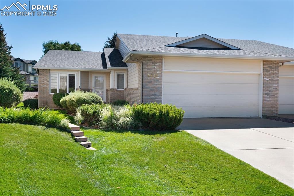 Image 2 of 38: Ranch-style house featuring brick siding, a shingled roof, concrete drivewa