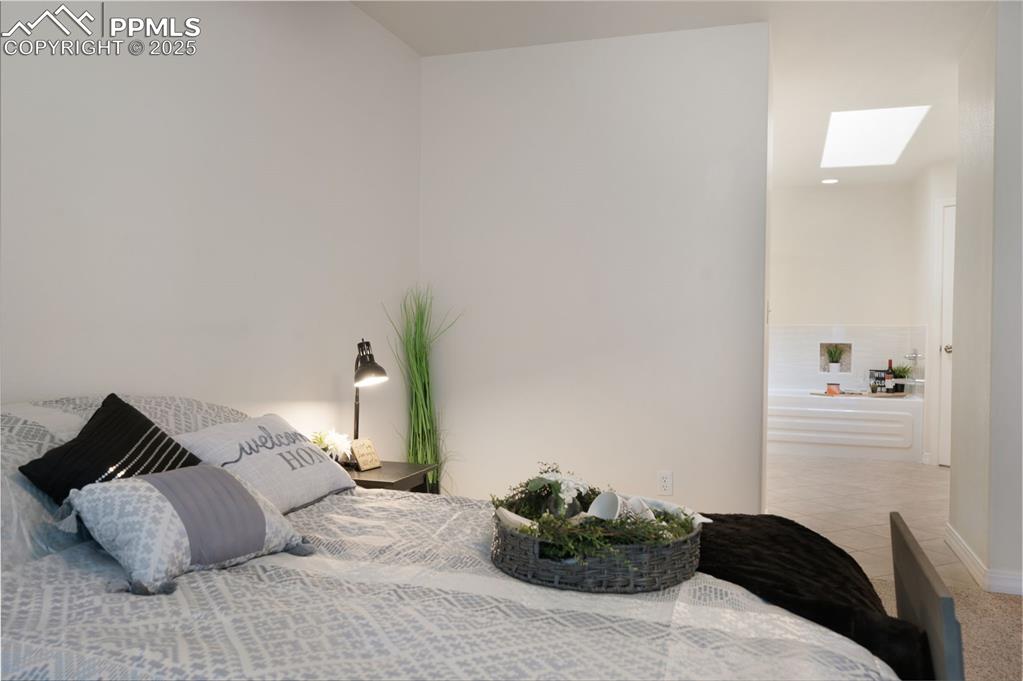 Image 20 of 38: Tiled bedroom with a skylight