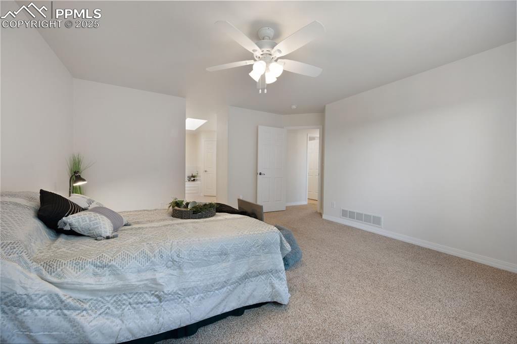 Image 21 of 38: Carpeted bedroom with baseboards and ceiling fan