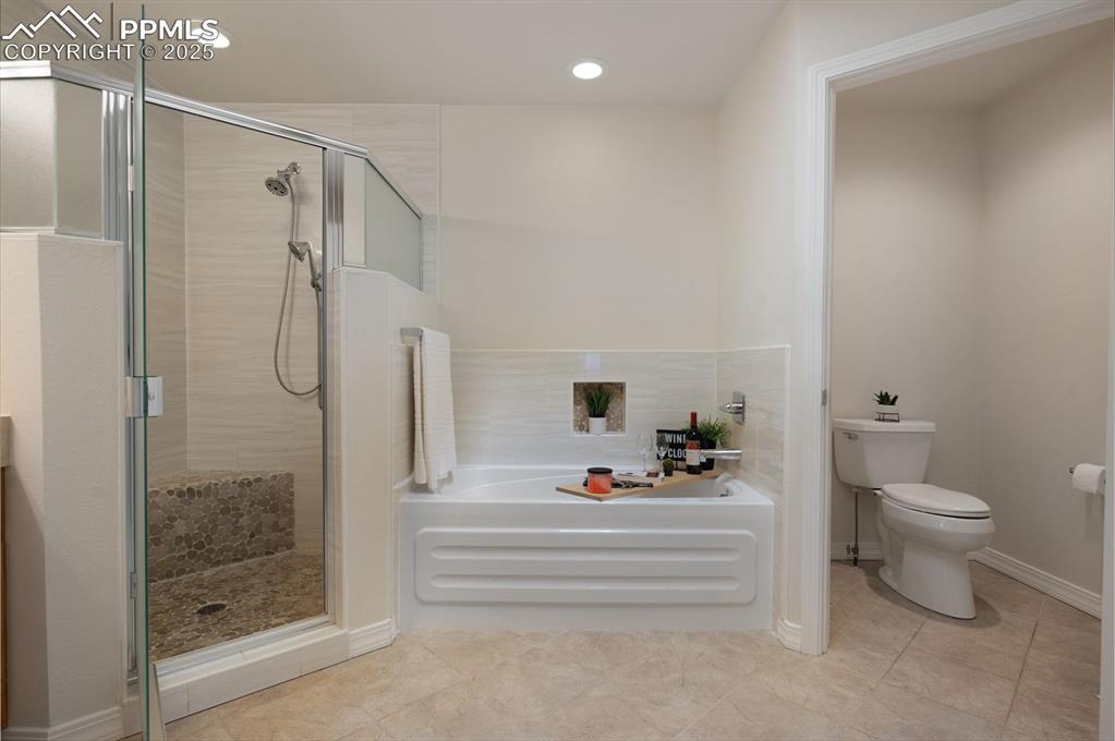Image 23 of 38: Bathroom featuring a garden tub, a shower stall, light tile patterned floor