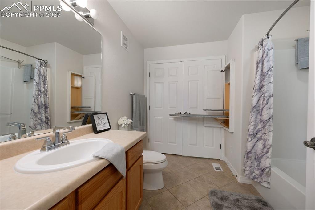 Image 26 of 38: Full bathroom featuring shower / bath combo, vanity, and light tile pattern