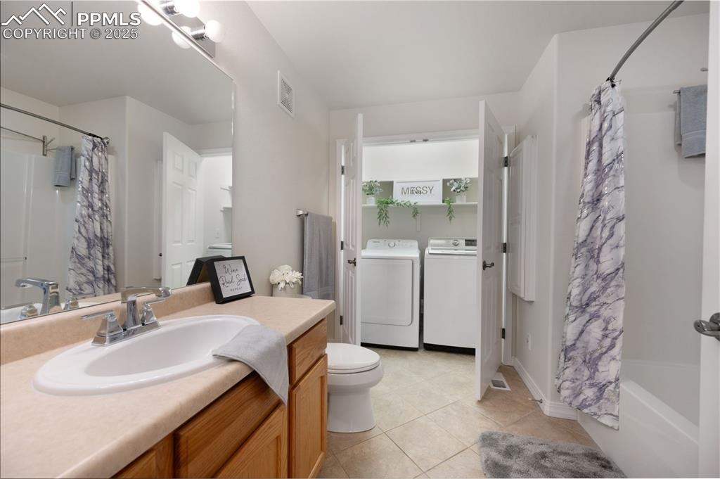 Image 27 of 38: Full bathroom with vanity, shower / tub combo with curtain, separate washer