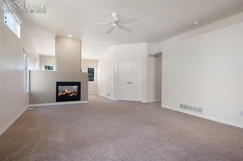 Image 3 of 38: Unfurnished living room with plenty of natural light, carpet floors, a mult