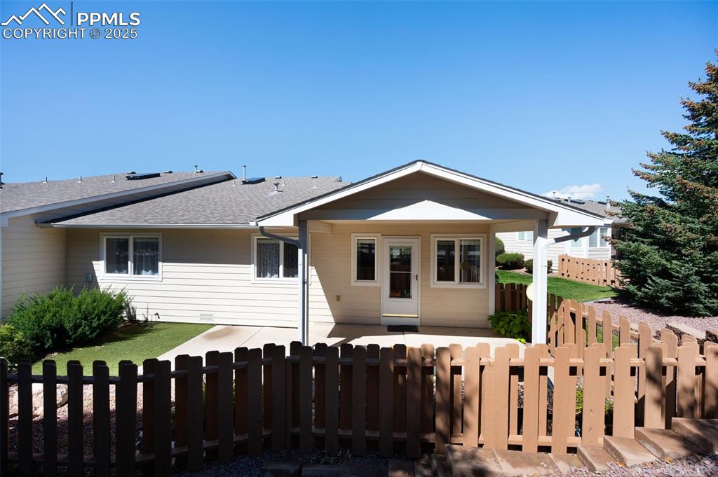 Image 33 of 38: View of front facade featuring a patio, a fenced front yard, and a shingled