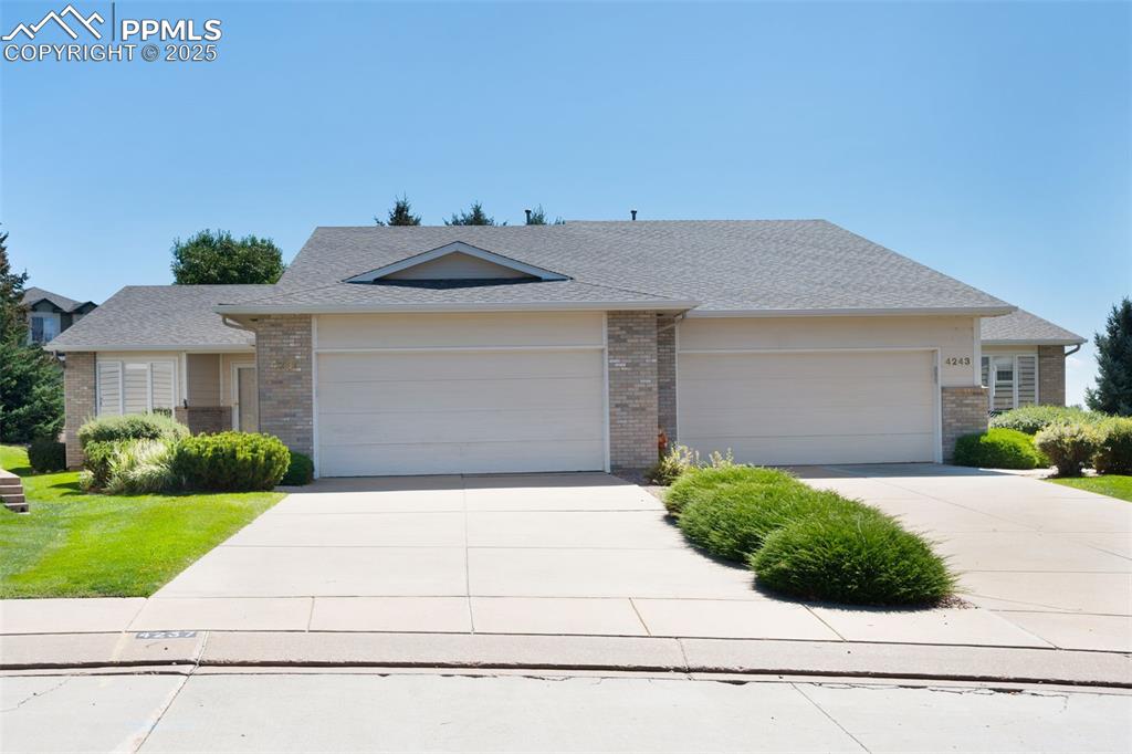 Image 36 of 38: View of front of home featuring roof with shingles, driveway, and brick sid