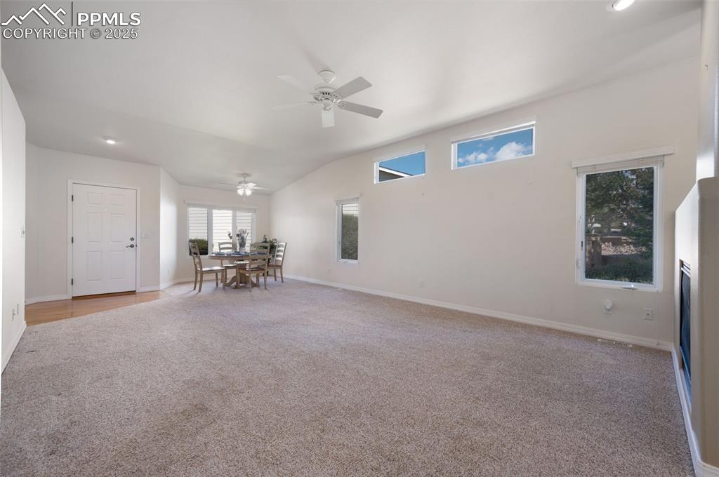 Image 7 of 38: Living room featuring light carpet, lofted ceiling, a ceiling fan, and rece