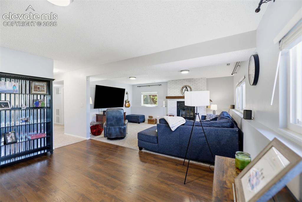 Image 24 of 37: Spacious living area featuring wood-finish flooring, recessed lighting, and