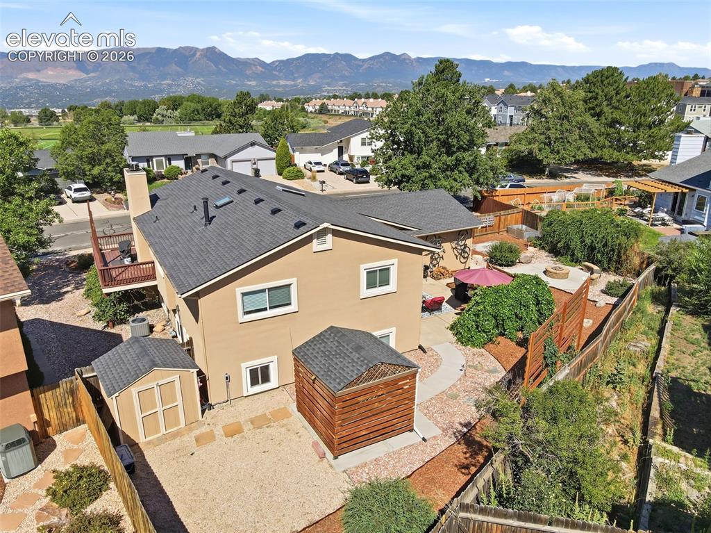 Image 35 of 37: Rear exterior featuring a tan stucco finish and a dark shingle roof