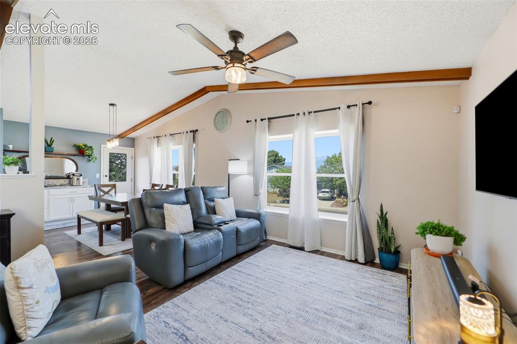 Image 8 of 37: Vaulted ceilings with wood-finish beams, wood-finish flooring, and multiple
