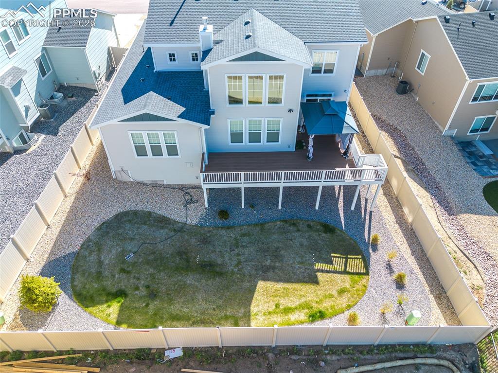 Image 4 of 9: Rear exterior featuring a multi-level deck with white railings, a blue cano