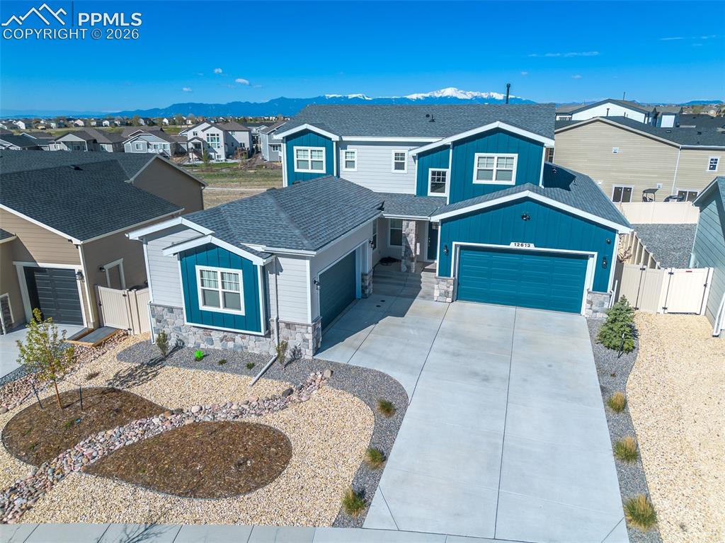 Image 6 of 9: Modern two-story residence with a multi-tone exterior, featuring a prominen