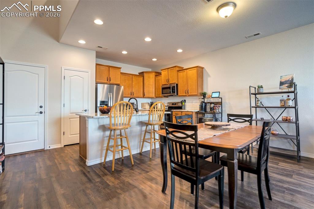 Image 10 of 48: Dining area open to the kitchen showing the breakfast bar, the pantry door 