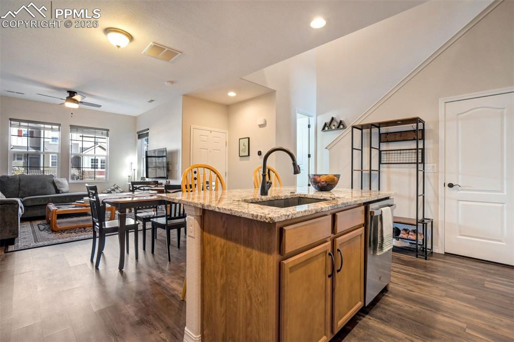 Image 13 of 48: Kitchen island with deep sink, and breakfast bar area. Showing the front do