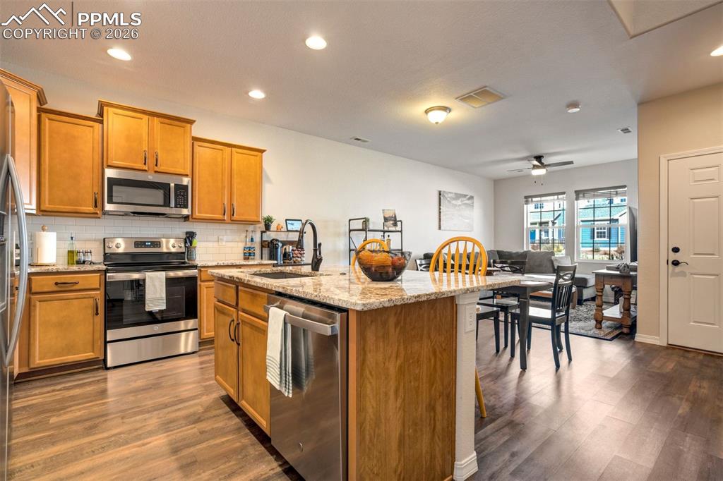 Image 16 of 48: Kitchen with stainless steel appliances, light stone countertops, kitchen i