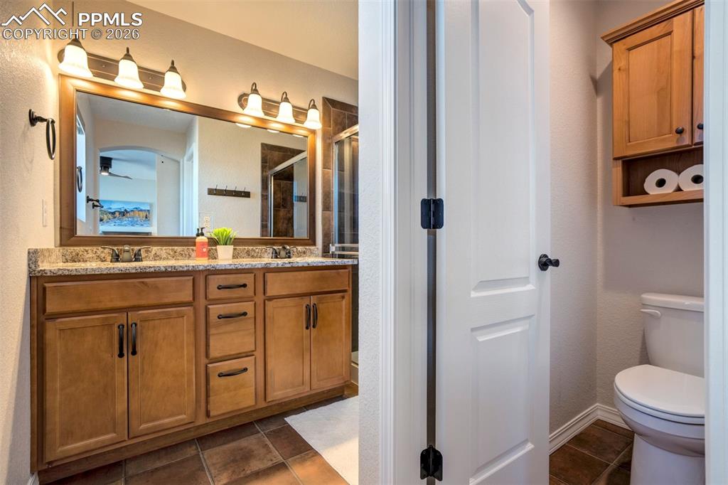 Image 29 of 48: Primary bathroom showing the double vanities, wood cabinets and separate to