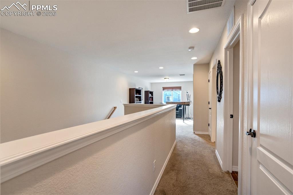 Image 30 of 48: Hallway from the Primary bedroom to the loft area.