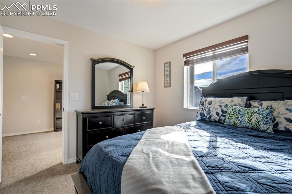 Image 32 of 48: Another view of the second light filled bedroom showing the door to the lof