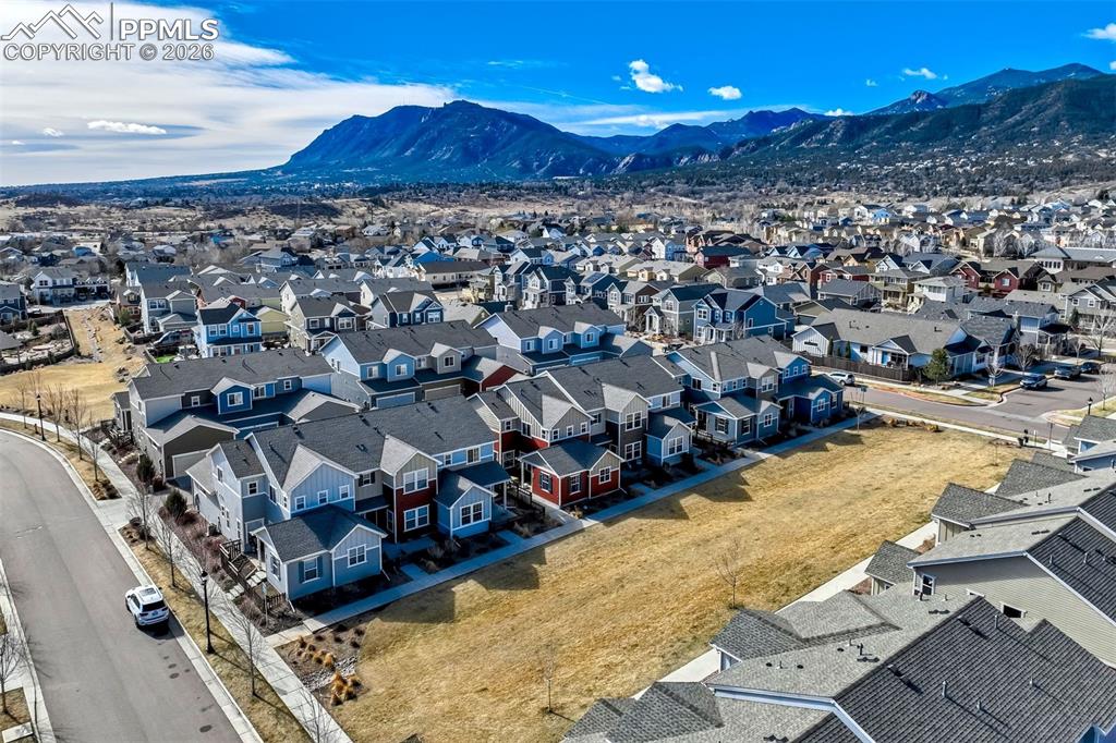 Image 45 of 48: Aerial view of residential area featuring a mountain backdrop