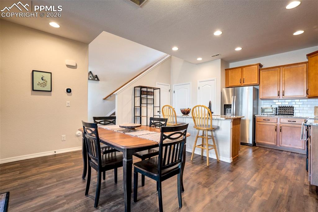Image 9 of 48: Dining area open to the kitchen and showing staircase. Recessed lighting.