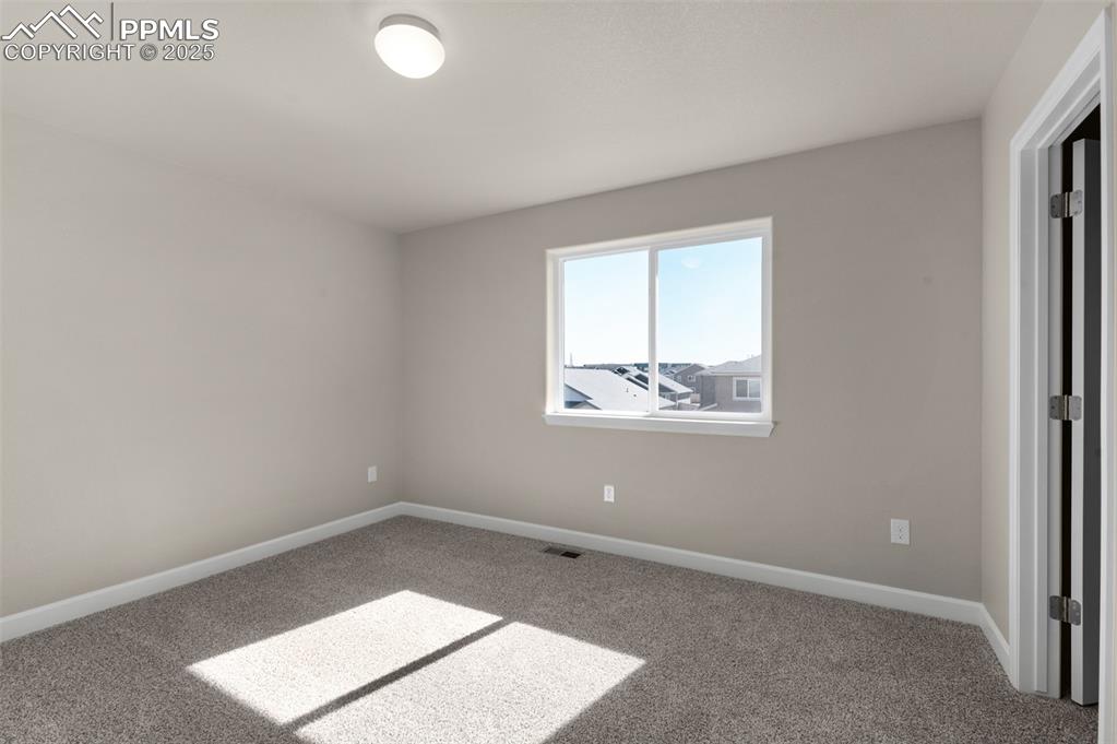 Image 10 of 13: Carpeted empty room with baseboards and visible vents
