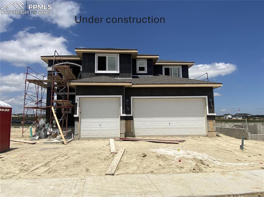 Image 2 of 13: View of front of property featuring a garage and a shingled roof