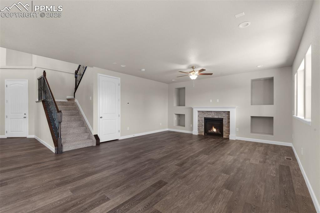 Image 5 of 13: Unfurnished living room featuring ceiling fan, dark wood finished floors, b