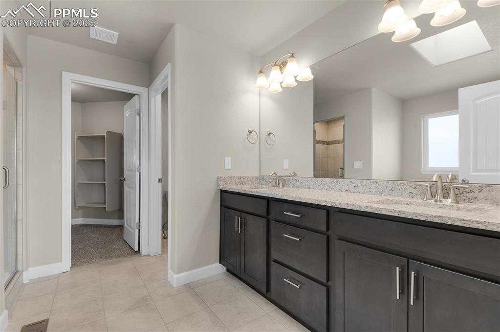 Image 9 of 13: Full bathroom featuring baseboards, a sink, visible vents, and a shower sta