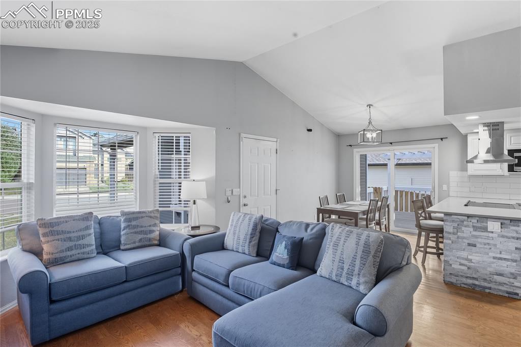 Image 10 of 32: Living room featuring vaulted ceiling and light wood-style flooring