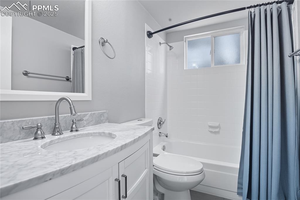 Image 15 of 32: Full bathroom with shower / tub combo with curtain and vanity