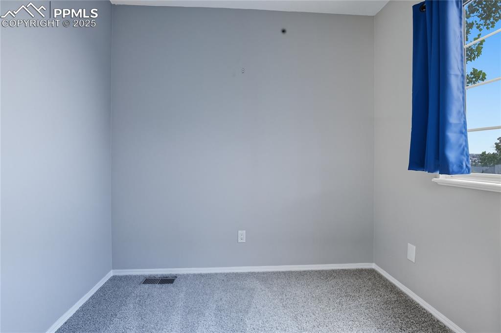 Image 16 of 32: Empty room with carpet floors and baseboards