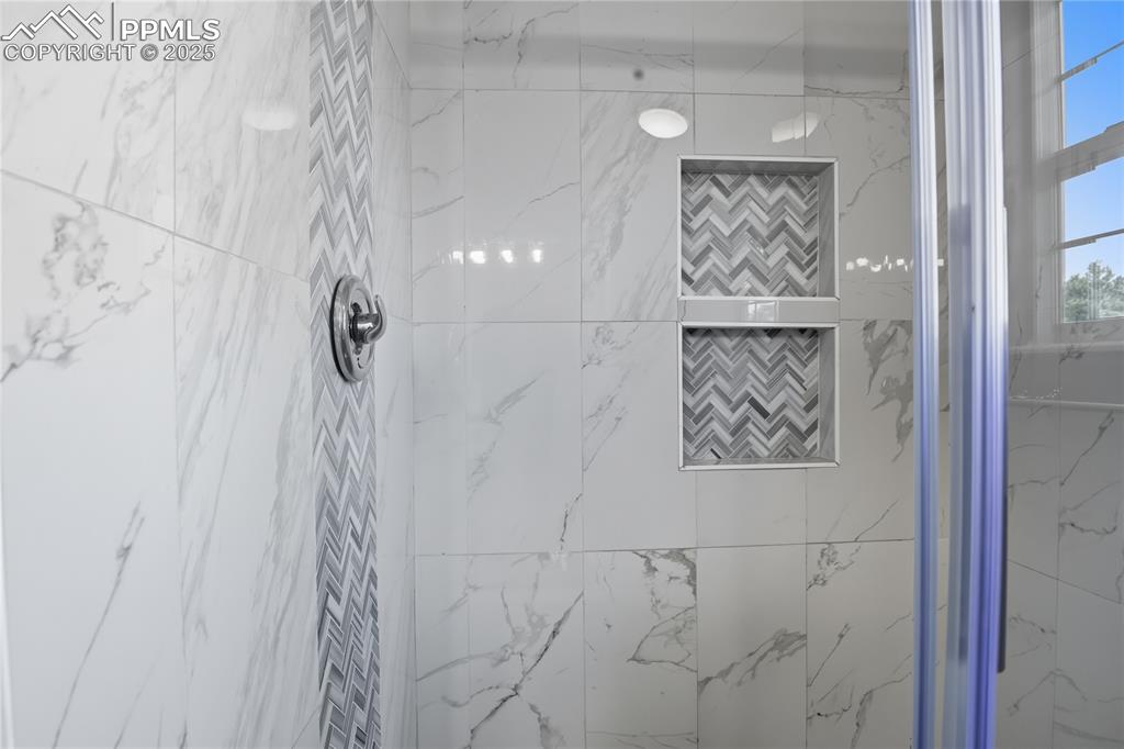 Image 22 of 32: Bathroom with a marble finish shower