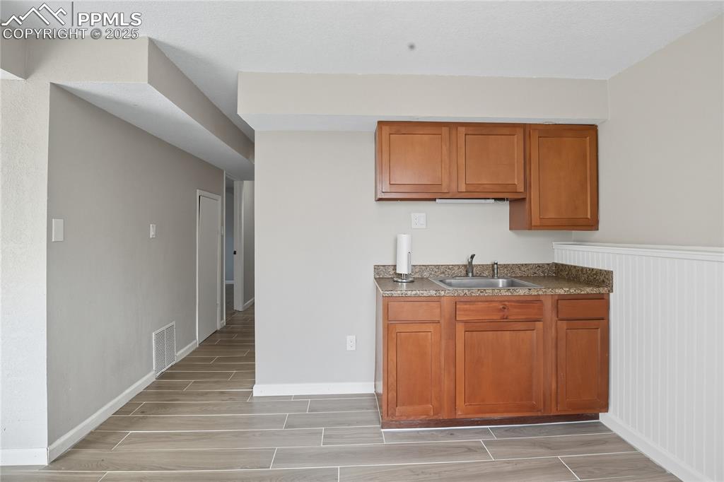 Image 25 of 32: Kitchen featuring brown cabinetry and wood finish floors