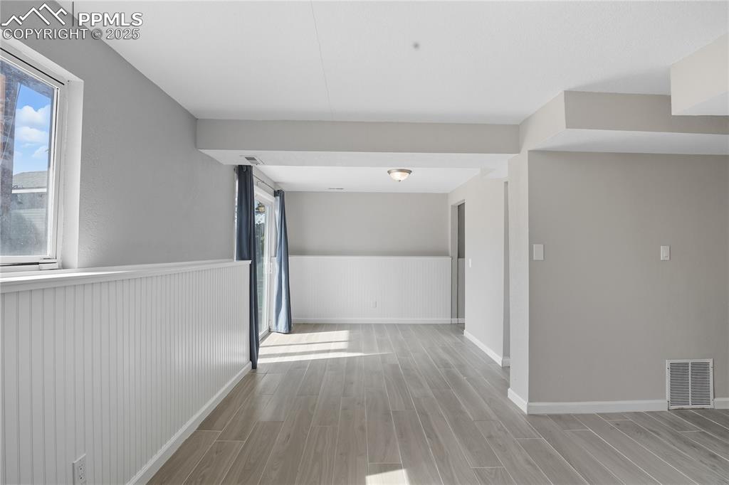 Image 26 of 32: Corridor featuring wood tiled floors, healthy amount of natural light, and