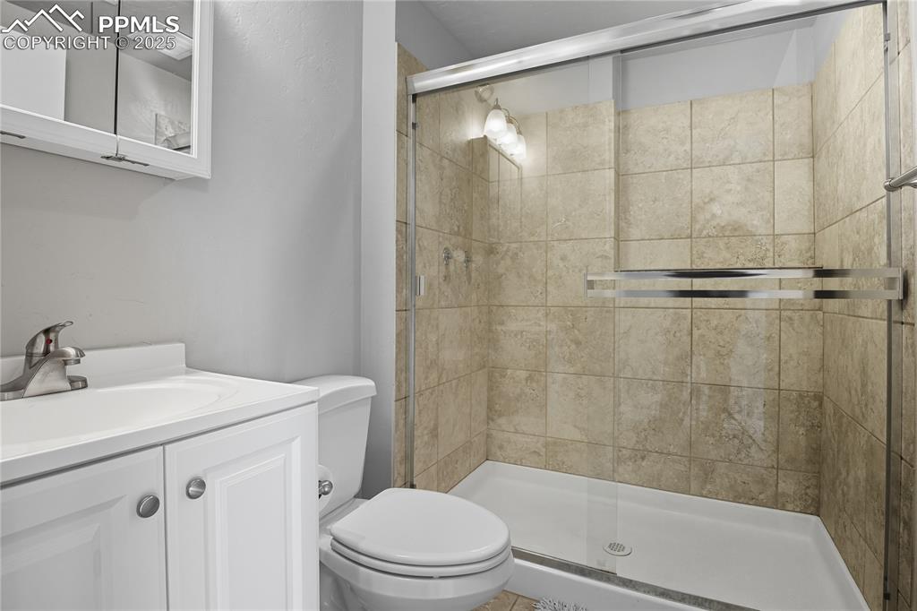 Image 27 of 32: Full bathroom with vanity and a stall shower