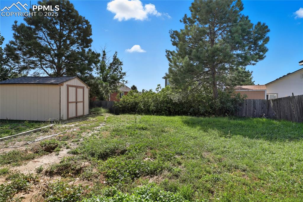 Image 30 of 32: View of yard featuring a storage unit