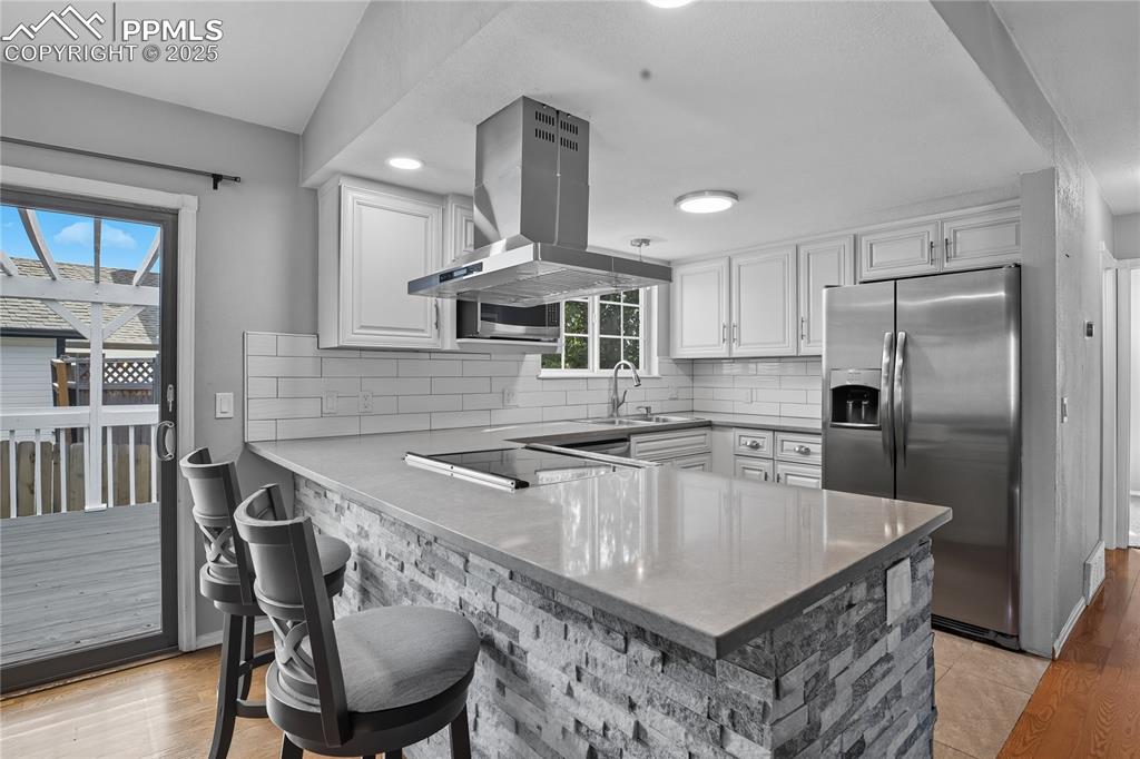 Image 6 of 32: Kitchen featuring stainless steel refrigerator with ice dispenser, backspla