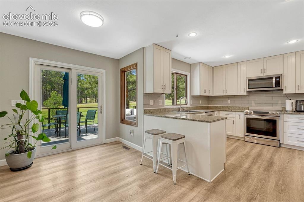 Image 14 of 49: Light and Bright living room with floor to ceiling