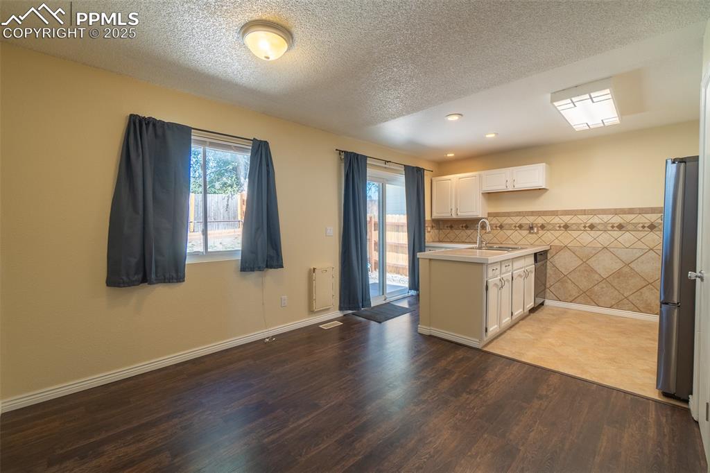 Image 13 of 42: Dining room facing kitchen with light countertops, white cabinetry, applian