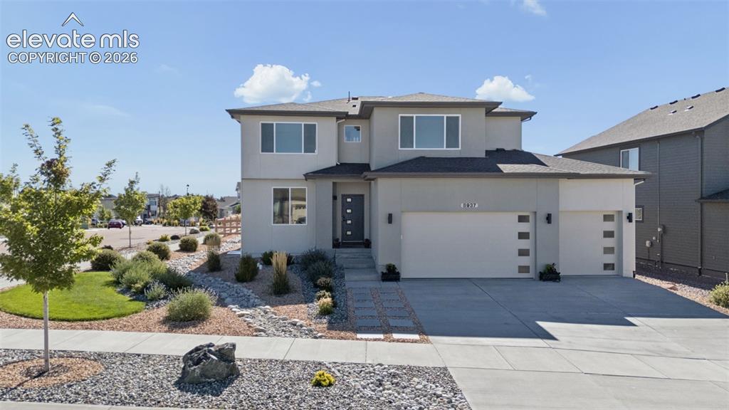 Caption: Contemporary stucco exterior with multiple large windows, a two-car garage with frosted pane accents