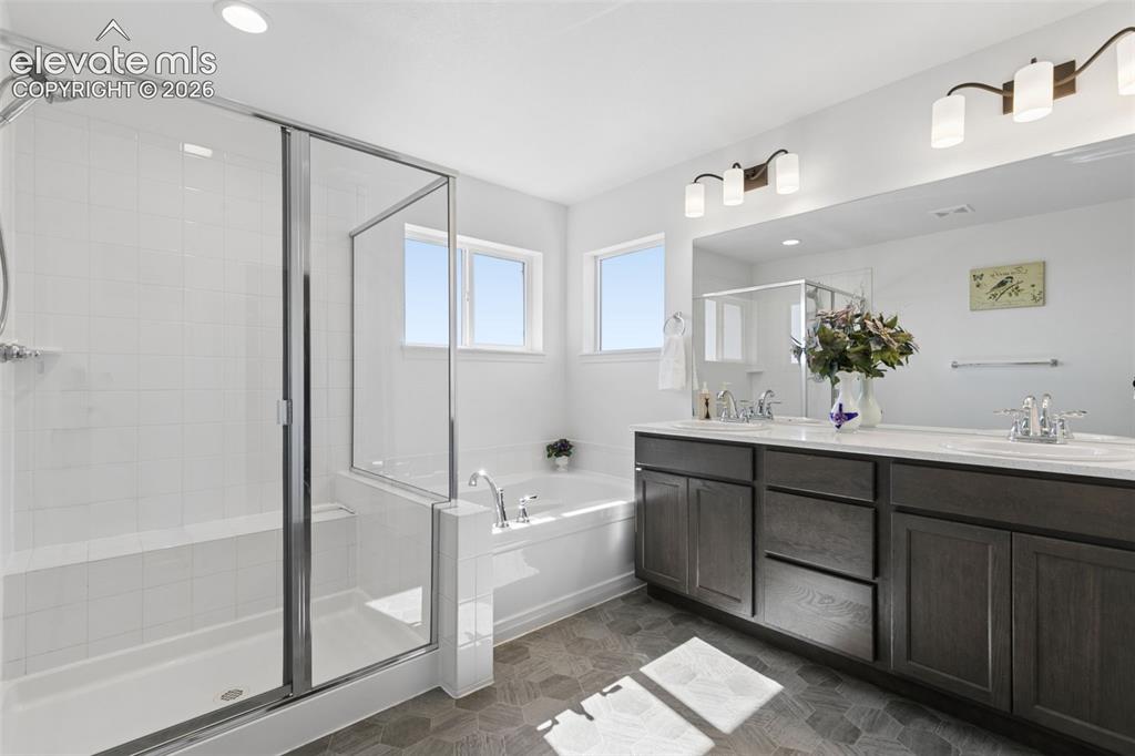 Image 13 of 26: Spacious bathroom featuring a glass-enclosed shower, built-in soaking tub, 