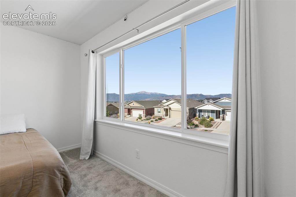 Image 15 of 26: Bright room featuring a large window with mountain view neutral carpeting,