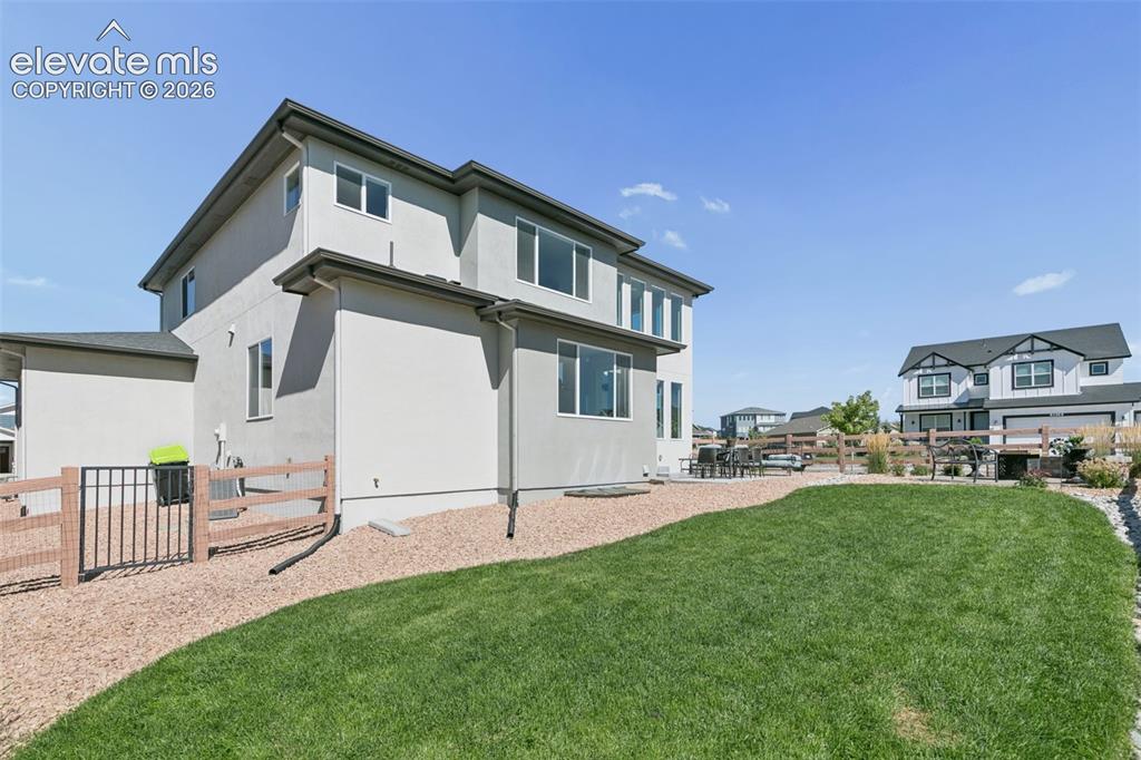 Image 24 of 26: Expansive lawn with a gravel pathway, leading to a patio area