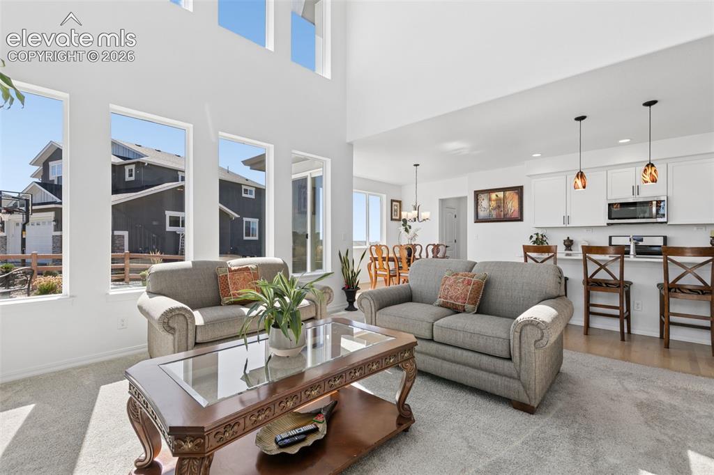 Image 5 of 26: Two-story living area with high ceilings and expansive windows